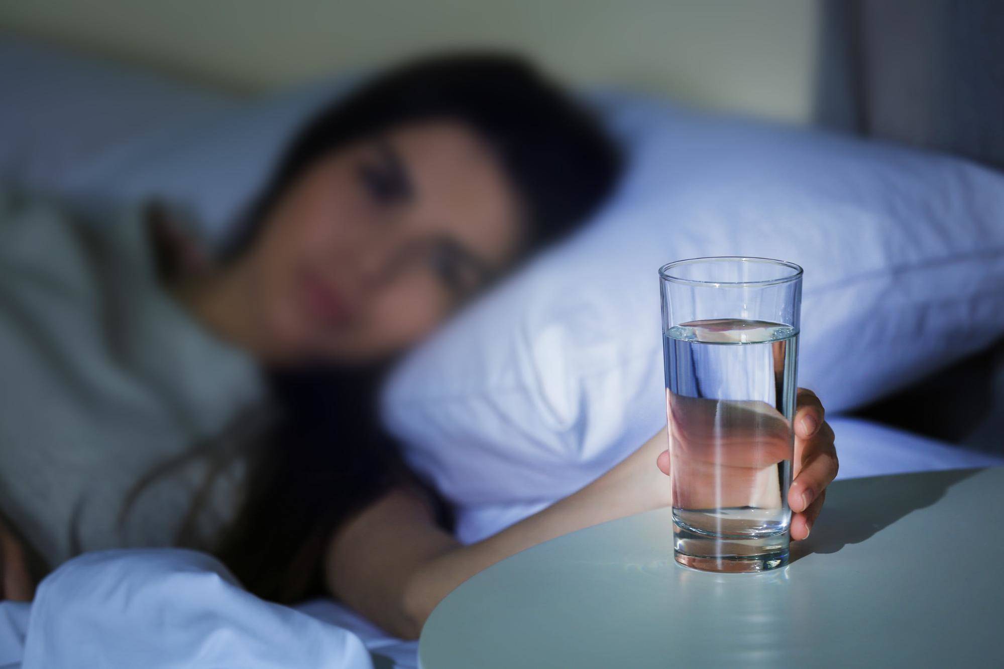 Вредно ли пить на ночь. Стакан воды на ночь. Стакан воды перед сном. Пить стакан воды перед сном. Стакан воды на постели.